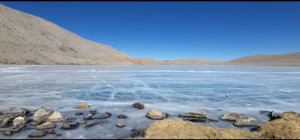 Reflection of snow‑capped peaks on Gurudongmar Lake’s icy surface